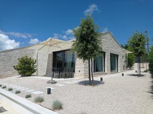 een huis met een boom en een paraplu bij Terra Histria - Boutique Stone House in Oprtalj