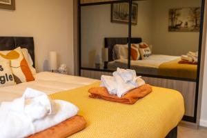 - une chambre avec 2 lits et des serviettes dans l'établissement Beautiful & Luxurious Home - Free Parking, Wi-Fi, à Heywood
