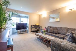 a living room with a couch and a table at Beautiful & Luxurious Home - Free Parking, Wi-Fi in Heywood