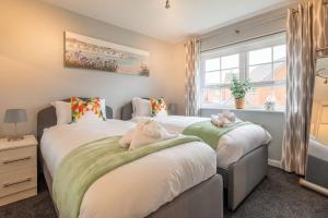 two beds in a bedroom with a window at Beautiful & Luxurious Home - Free Parking, Wi-Fi in Heywood