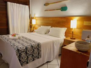 Schlafzimmer mit einem großen weißen Bett und Holzwänden in der Unterkunft Pousada Estrela do Mar Noronha in Fernando de Noronha