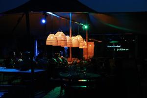 a restaurant with people sitting at tables at night at Tiny House by the water - de Schans Alphen in Alphen