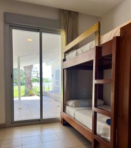 a bedroom with two bunk beds and a sliding glass door at Albergue Zaragoza Camping in Zaragoza