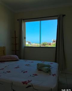 1 dormitorio con cama y ventana grande en Pousada dos Reis, en Barra de Ibiraquera