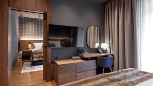 a bedroom with a bed and a desk with a mirror at Bor Hotel by Karisma in Zlatibor