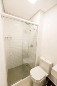 a bathroom with a toilet and a glass shower at Ap no Jaçatuba para locação in Santo André