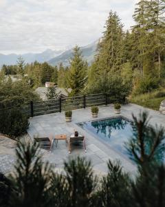 a person sitting on a chair next to a swimming pool at LeCrans in Crans-Montana