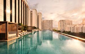 a large pool of blue water with tall buildings at Taj The Trees, Mumbai in Mumbai