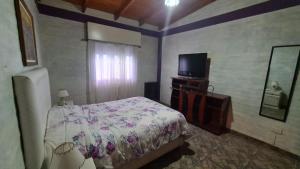 sypialnia z łóżkiem i telewizorem z płaskim ekranem w obiekcie Sonidos del Mar w mieście Balneario El Condor