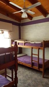 a bedroom with two bunk beds and a ceiling fan at Sonidos del Mar in Balneario El Condor