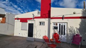 budynek z dwoma krzesłami i dom w obiekcie Sonidos del Mar w mieście Balneario El Condor