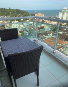 una mesa y sillas en un balcón con vistas en Macaé Ramada Flat RJ en Macaé
