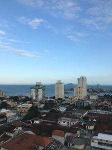 vistas a una ciudad con edificios y al océano en Macaé Ramada Flat RJ en Macaé