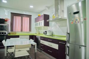 a kitchen with a stainless steel refrigerator and a table at Donde habita el olvido in Baeza