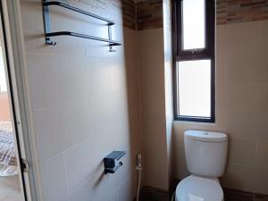 a bathroom with a toilet and a window at Pengok Kidul 21 in Demangan