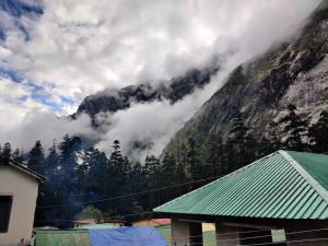 einen Blick auf einen Berg mit Wolken im Hintergrund in der Unterkunft Hotel Preetam Uttarakhand in Lokpāl