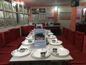 a table in a restaurant with plates of food at Hotel Preetam Uttarakhand in Lokpāl