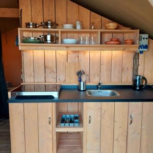 a kitchen with wooden cabinets and a sink at Glamping Vive Tus Suenos -Equilibrio- Caminito del Rey in Alora