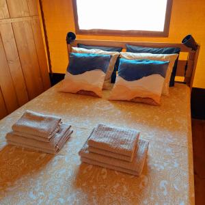 a bed with four stacks of towels on it at Glamping Vive Tus Suenos -Equilibrio- Caminito del Rey in Alora