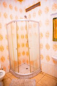 a shower with a glass door in a bathroom at RIGTH Homes in Kigali