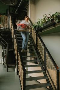 a woman walking down a staircase holding a basket at Hotel Jansen Amsterdam Bajeskwartier in Amsterdam
