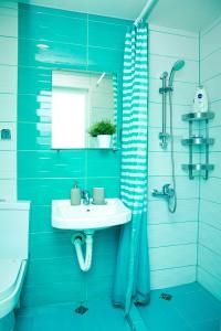 a blue bathroom with a sink and a shower at Апартаменти Дача in Varna City