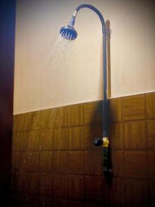 eine Dusche mit einem an der Wand befestigten Wasserschlauch in der Unterkunft Residence Inn in Angunakolapelessa