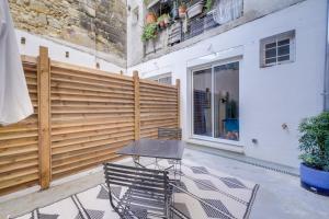 eine Terrasse mit 2 Stühlen, einem Tisch und einem Zaun in der Unterkunft Lovely studio in Chartrons with terrace in Bordeaux