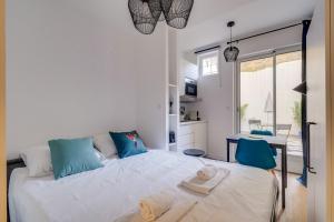 ein Schlafzimmer mit einem großen Bett mit blauen Kissen in der Unterkunft Lovely studio in Chartrons with terrace in Bordeaux