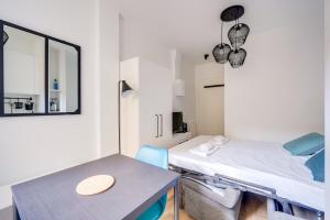 ein Krankenhauszimmer mit einem Bett und einem Tisch in der Unterkunft Lovely studio in Chartrons with terrace in Bordeaux