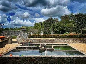 una piscina de agua en un jardín con nubes en el cielo en Residence Inn, en Angunakolapelessa