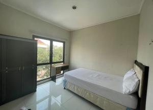 ein kleines Schlafzimmer mit einem Bett und einem Fenster in der Unterkunft OYO 93500 Rizki Residence TOS Syariah in Jakarta