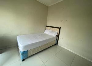 ein kleines Bett in einer Ecke eines Zimmers in der Unterkunft OYO 93500 Rizki Residence TOS Syariah in Jakarta