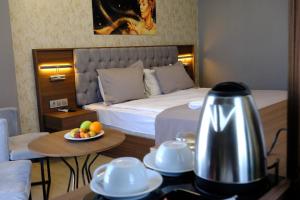 a hotel room with a bed and a table with a bowl of fruit at GRAND SALİZZE HOTEL in Kestel
