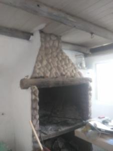 a large stone fireplace in a room with at Casa Rosa in Balneario Claromecó