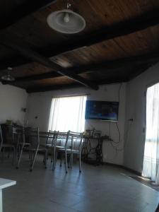 jadalnia ze stołem, krzesłami i oknami w obiekcie Casa Rosa w mieście Balneario Claromecó