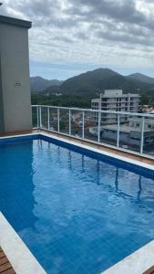 a large blue swimming pool on top of a building at Lindo apartamento Ubatuba in Ubatuba