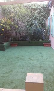 un patio con césped verde y un banco en él en 2p. Jardin calme centre-ville, en Marsella