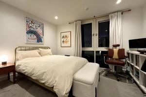 a bedroom with a bed and a desk and a television at Stylish 2BD Flat wIncredible View of London - Bow in London