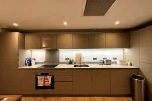a kitchen with a sink and a stove at Stylish 2BD Flat wIncredible View of London - Bow in London