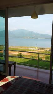 Habitación con ventana grande con vistas al agua. en Chomdao Baan Manisa, en Kiriwong