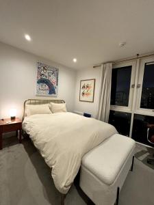 Säng eller sängar i ett rum på Stylish 2BD Flat wIncredible View of London - Bow