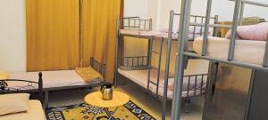 Habitación con 3 literas y sofá en Muscat Hostel 2300, en Mascate