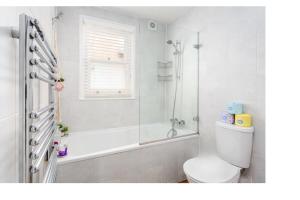 y baño con aseo, bañera y ducha. en Chic 3BD Maisonette wRoof Terrace - Wandsworth!, en Londres