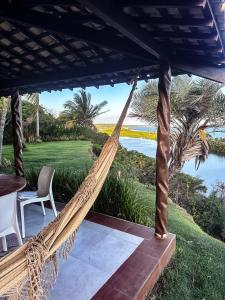 a hammock on a patio with a view of the ocean at Spa da Alma in Coruripe