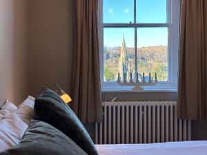 a bedroom with a window with a view of a church at 4 Studio House Ambleside in Ambleside