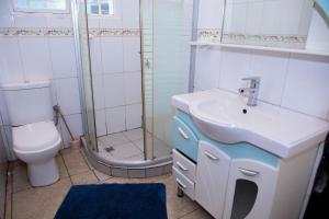 a bathroom with a sink and a toilet and a shower at RIGTH Homes in Kigali