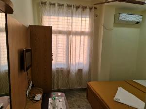 a bedroom with a window and a table with bottles on it at Vijay Shree Inn in Vellore