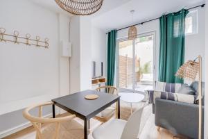 ein Wohnzimmer mit einem Tisch und einem Sofa in der Unterkunft Beautiful apartment in Chartrons with terrace in Bordeaux