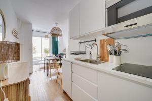 eine Küche mit weißen Schränken und einem Waschbecken in der Unterkunft Beautiful apartment in Chartrons with terrace in Bordeaux
